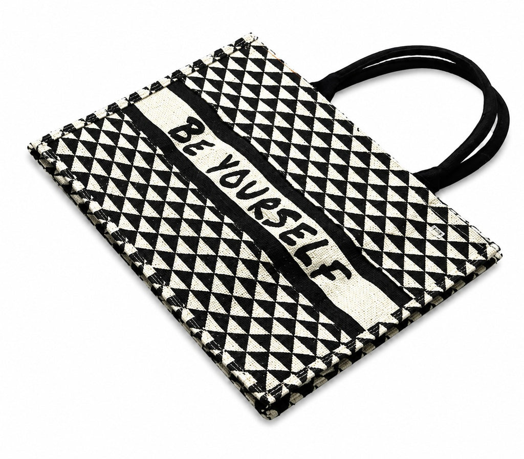 Tap2Own Be Yourself graphic tote bag with black and white geometric pattern and black handles.