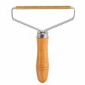 Tap2Own reusable fabric fuzz remover tool with metal spring bar and wooden handle.