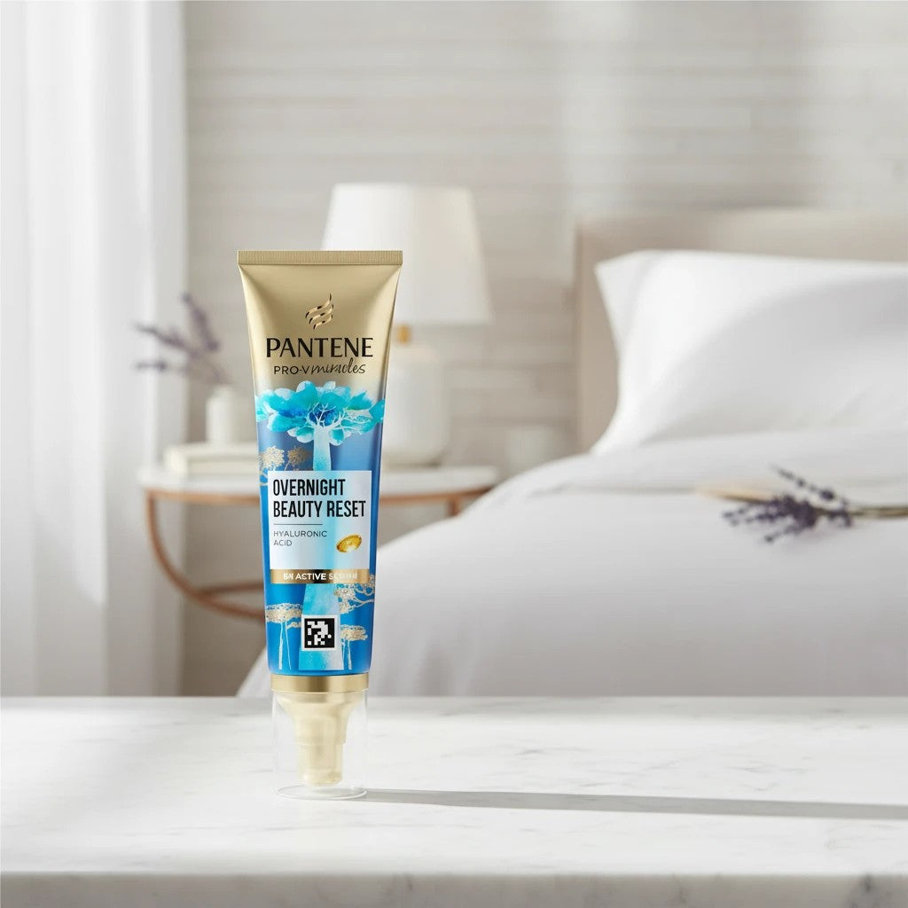 Tap2Own Pantene Pro-V Miracles Overnight Beauty Reset hair serum tube on a marble surface in a bedroom setting.