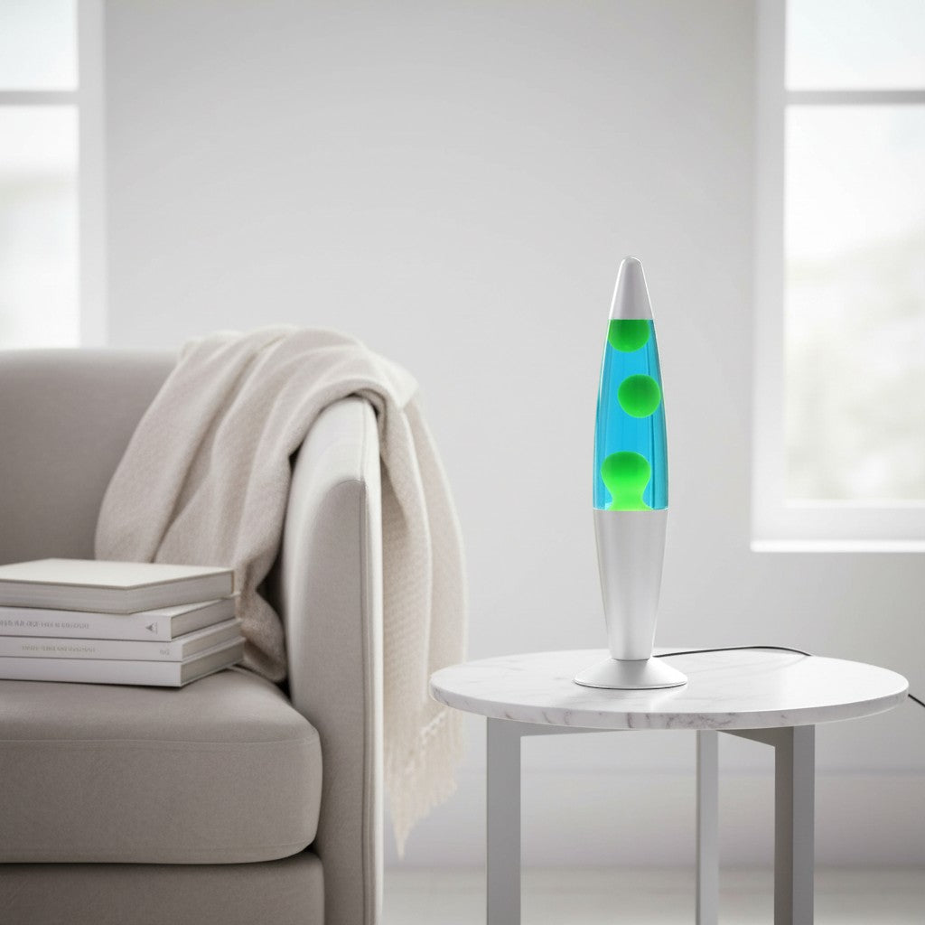 Tap2Own retro lava lamp with green blobs in blue liquid and a silver base, placed on a marble side table.