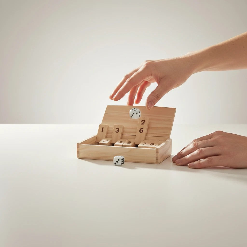 Tap2Own Shut The Box dice game with wooden box, numbered tiles, and dice. Hands playing the game.