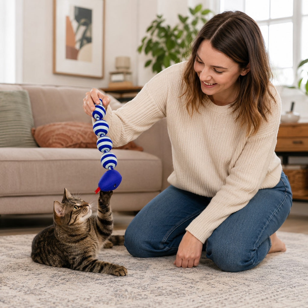 Tap2Own blue and white striped plush snake cat toy with a blue mouse head, held by a woman playing with a tabby cat.