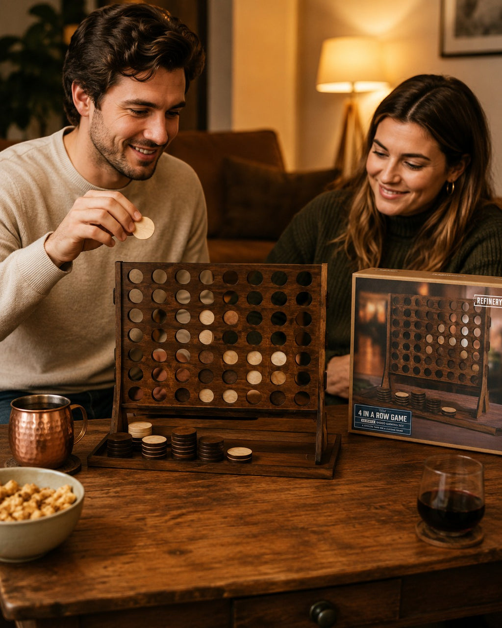 Tap2Own Wooden 4 in a Row game with a man dropping a disc, set on a wooden table with snacks and drinks.